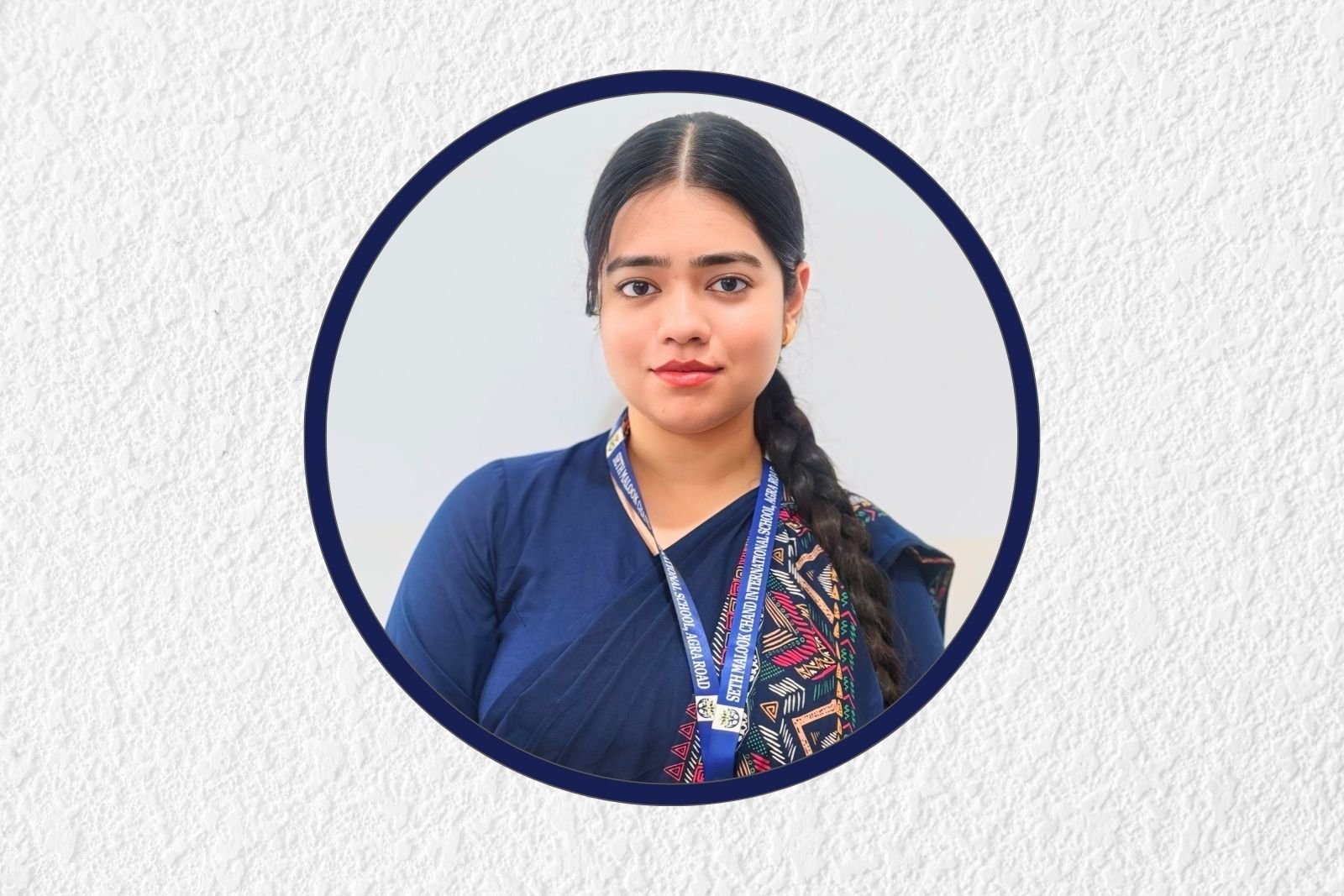 Portrait of a young woman with dark hair in a braid, wearing a blue outfit and a lanyard, inside a circular navy frame with textured background.