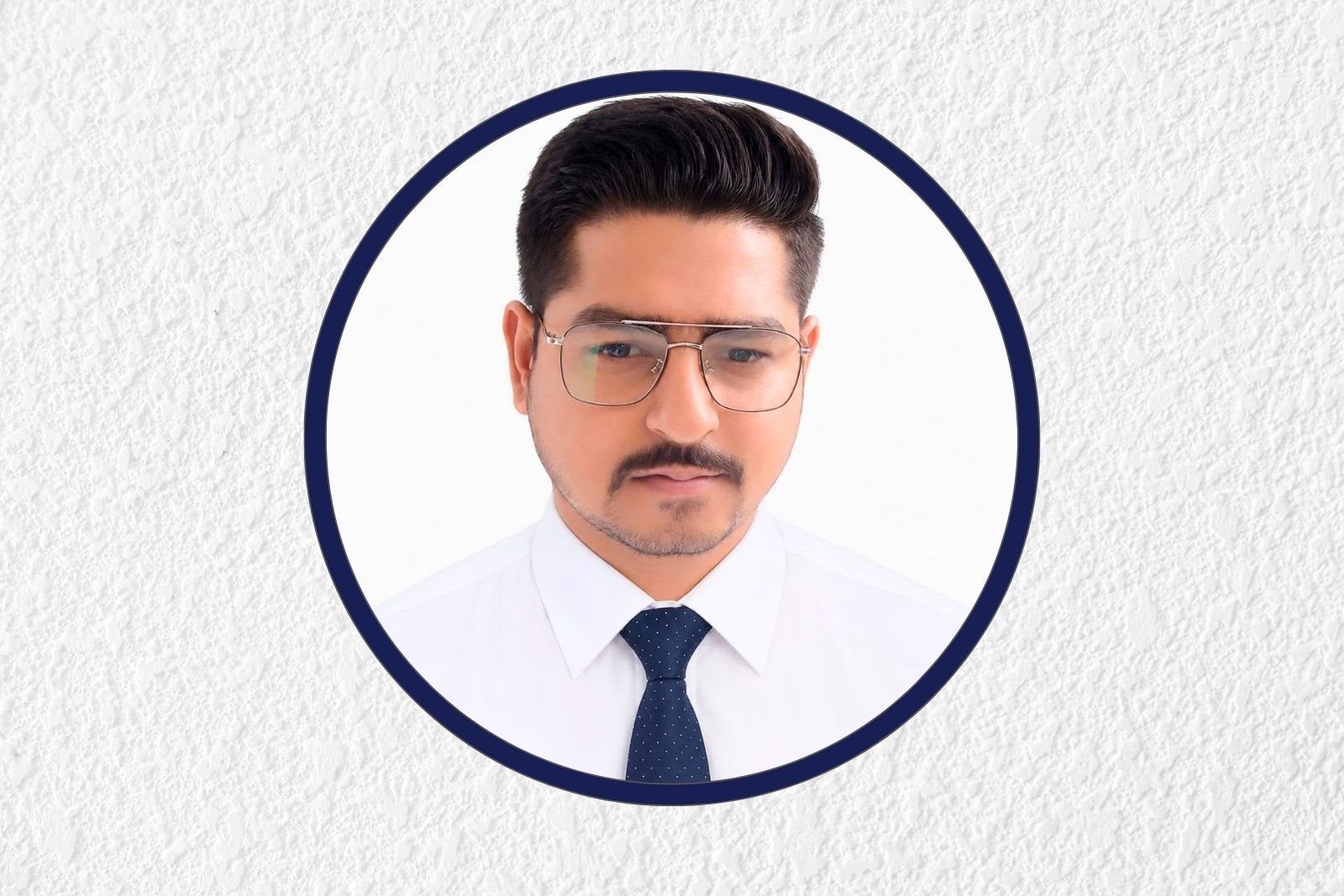 Professional headshot of a man in a white shirt and navy tie, framed in a circular navy border on a textured background.